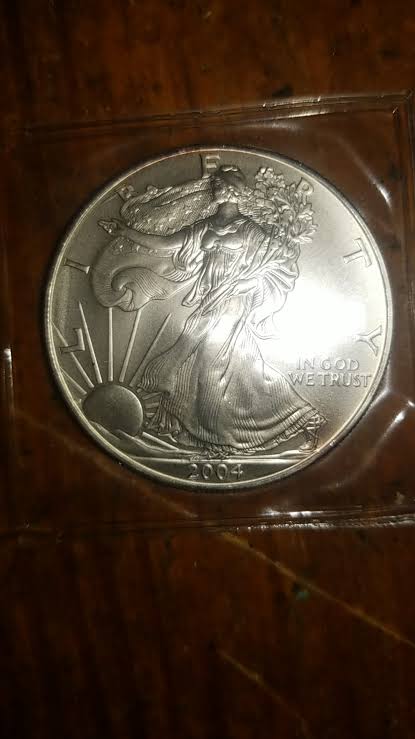 2004 American Silver Eagle off-center strike showing shifted design and blank crescent at coin edge